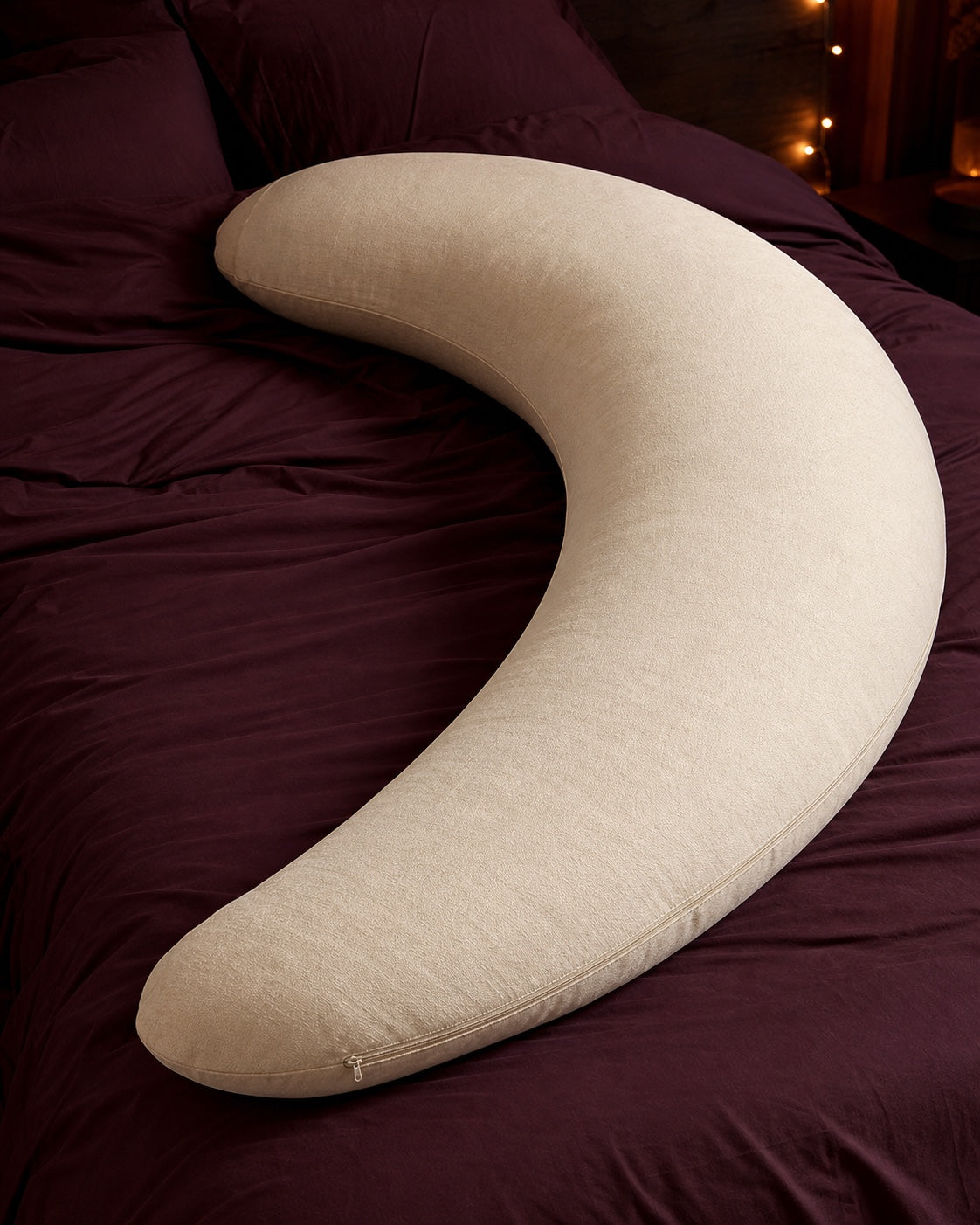 Oversized cream crescent body pillow on plum bedding
